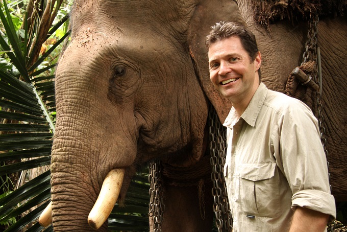 Steve Leonard with an Elephant in Laos who has recovered well from a medical procedure to fix an infected leg - Image Credit: BBC